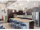 Modern kitchen featuring dark cabinetry, stainless steel appliances, pendant lighting and a spacious island with seating at 4290 Solace St, Las Vegas, NV 89135