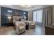 This main bedroom offers an elegant blue accent wall, cozy seating area, and stylish window coverings at 4290 Solace St, Las Vegas, NV 89135