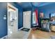 Welcoming entryway featuring blue accent walls, a stylish white door, and tile flooring leading to kitchen at 4629 Denwood Dr, Las Vegas, NV 89147