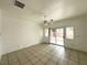 Living room featuring tile flooring, a ceiling fan, and sliding glass doors to the backyard at 4713 Vista Del Rey Ct, North Las Vegas, NV 89031