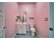 Pink bathroom featuring modern sink and cabinets, toilet, and tiled flooring at 5091 E Beacon Ridge Dr, Pahrump, NV 89061