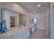 Modern bathroom with double vanity sinks, quartz countertops, large mirrors, and a separate glass-enclosed shower at 5091 E Beacon Ridge Dr, Pahrump, NV 89061