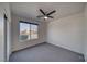 Bright bedroom with neutral carpet, a ceiling fan, and a large window with neighborhood views at 5091 E Beacon Ridge Dr, Pahrump, NV 89061