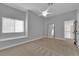 Neutral bedroom features a ceiling fan, large window, and an open doorway at 5205 Coral Glow Ct, Las Vegas, NV 89149