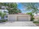 Attached two-car garage with automatic doors, complemented by a paved driveway and mature landscaping at 5205 Coral Glow Ct, Las Vegas, NV 89149