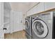 Convenient laundry room with modern washer and dryer, storage shelves, and a utility sink at 5205 Coral Glow Ct, Las Vegas, NV 89149