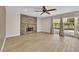 Spacious living room featuring a stone fireplace, ceiling fan, and sliding glass doors to outdoor space at 5205 Coral Glow Ct, Las Vegas, NV 89149