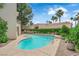Backyard featuring a kidney-shaped pool, lush landscaping, and patio at 5205 Coral Glow Ct, Las Vegas, NV 89149