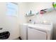 Bright laundry room with modern washer and dryer units, and convenient shelving at 6121 Mission Gorge Ct, Las Vegas, NV 89130
