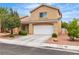 Charming two-story home featuring a tile roof, a spacious two-car garage, and mature landscaping at 682 E Sole Addiction Ave, Las Vegas, NV 89183