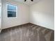 A bright bedroom featuring a window and neutral carpet flooring at 6918 Dandelion Park Ave, Las Vegas, NV 89113