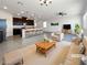 Bright, open living room with modern furnishings, seamlessly connected to the kitchen and dining area at 6918 Dandelion Park Ave, Las Vegas, NV 89113