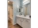 Bright bathroom featuring a white vanity, tile floors, and a view to a shower/tub at 7240 Wandering Star Ct, Las Vegas, NV 89131
