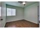 Cozy bedroom with a ceiling fan, wood-look floors, and a bright window at 7240 Wandering Star Ct, Las Vegas, NV 89131