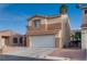 Two-story tan home featuring a white garage door and desert landscaping at 7240 Wandering Star Ct, Las Vegas, NV 89131