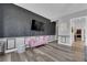 Stylish bedroom showcases wood-look floors, TV, and pink sofa with accent wall at 7258 W Le Baron Ave, Las Vegas, NV 89178