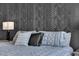 A comfortable bed with decorative pillows sits in front of a stylish accent wall at 7258 W Le Baron Ave, Las Vegas, NV 89178