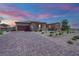Single story home featuring desert landscaping, tan exterior paint, and a three-car garage at 7258 W Le Baron Ave, Las Vegas, NV 89178
