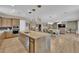 Open-concept kitchen boasts an expansive granite island, stainless steel appliances, and hardwood flooring at 7258 W Le Baron Ave, Las Vegas, NV 89178