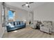 Inviting living room with a blue sofa, patterned armchairs, and plenty of natural light at 7258 W Le Baron Ave, Las Vegas, NV 89178