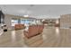 Open-concept living room showcasing hardwood floors, modern lighting, and seamless flow into the kitchen and dining areas at 7258 W Le Baron Ave, Las Vegas, NV 89178