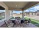 Cozy covered patio has outdoor seating around a built-in stone fire pit at 7258 W Le Baron Ave, Las Vegas, NV 89178