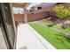 Low maintenance backyard featuring artificial turf, desert landscaping, and a covered patio at 7325 Perkins Hill St, Las Vegas, NV 89166