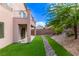 The backyard features artificial grass, a rock bed, and a view of the upstairs balcony at 7325 Perkins Hill St, Las Vegas, NV 89166