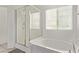 Bright bathroom with a shower and separate tub beneath a window with bright, natural light at 7325 Perkins Hill St, Las Vegas, NV 89166