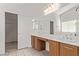 Bright bathroom with dual sinks, wood cabinets, and large mirror at 7325 Perkins Hill St, Las Vegas, NV 89166