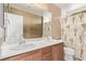 A bathroom with double sinks, wooden cabinets, and a shower/tub combination at 7325 Perkins Hill St, Las Vegas, NV 89166