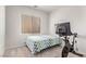 Bright bedroom with a bed, an exercise bike, and a window with blinds at 7325 Perkins Hill St, Las Vegas, NV 89166