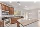 Bright kitchen with stainless steel appliances, wood cabinetry, granite countertops, and recessed lighting at 7325 Perkins Hill St, Las Vegas, NV 89166