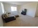 Upstairs living room features a sofa, ottoman, TV, and plenty of natural light from the windows at 7325 Perkins Hill St, Las Vegas, NV 89166
