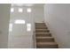 Carpeted stairs lead to the second level of the home, with large windows for natural light at 7325 Perkins Hill St, Las Vegas, NV 89166