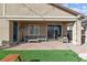 A covered patio featuring comfortable seating adjoins the backyard with playground at 7616 Quail Dust St, North Las Vegas, NV 89084