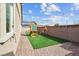 Spacious backyard with a playset, brick paved patio, and lush synthetic lawn at 7616 Quail Dust St, North Las Vegas, NV 89084