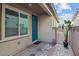 Charming side entry with teal door and paver flooring, complemented by a potted plant and wrought iron gate at 7616 Quail Dust St, North Las Vegas, NV 89084