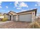 Garage view showcasing the home's paver driveway, stone accents, and three-car garage with neutral color scheme at 7616 Quail Dust St, North Las Vegas, NV 89084