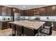 Open-concept kitchen featuring granite countertops, stainless steel appliances, and a spacious island with barstool seating at 7616 Quail Dust St, North Las Vegas, NV 89084