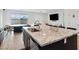 Kitchen island features granite countertops, stainless steel sink, and barstool seating, offering seamless indoor-outdoor flow at 7616 Quail Dust St, North Las Vegas, NV 89084