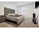 Modern main bedroom with a large upholstered headboard and sleek bedside tables at 7616 Quail Dust St, North Las Vegas, NV 89084