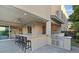 A modern outdoor kitchen area featuring a large granite bar, built-in grill, and seamless access to the home's interior at 778 Horizon Canyon Dr, Henderson, NV 89052