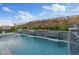 A luxurious swimming pool with a modern water feature and a serene backdrop of lush landscaping and a hillside at 778 Horizon Canyon Dr, Henderson, NV 89052