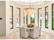 Elegant dining room with a stunning chandelier and views of the pool and lush landscaping at 8895 S Tenaya Way, Las Vegas, NV 89113