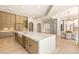 Bright, modern kitchen featuring a large island, seamless wood cabinetry, and elegant light fixtures at 8895 S Tenaya Way, Las Vegas, NV 89113