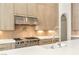 Modern kitchen featuring sleek wood cabinetry, stainless steel appliances, and a pristine white countertop at 8895 S Tenaya Way, Las Vegas, NV 89113