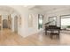 Staged living room with a piano, light wood floors, white walls, and a view to a landscaped backyard at 8895 S Tenaya Way, Las Vegas, NV 89113