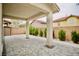 Covered back patio with pavers, trimmed bushes, brick wall and a peaked roof at 9144 Clear Sky Ave, Las Vegas, NV 89178