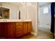 Bathroom featuring double sinks, vanity, tile flooring and a walk in shower with a window at 9144 Clear Sky Ave, Las Vegas, NV 89178